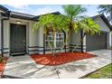 Beautiful single-story home with mature palm trees, grey walls, black trim, and covered front entrance at 6528 Shepherd Oaks Pass, Lakeland, FL 33811