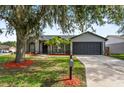 Charming single-story home featuring well-maintained lawn, two-car garage, and beautiful landscaping at 6528 Shepherd Oaks Pass, Lakeland, FL 33811