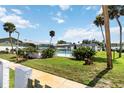 Community pool area with fence, landscaping, and nearby two-story condo buildings at 840 Center Ave # 80, Daytona Beach, FL 32117