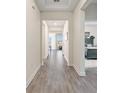Bright hallway featuring wood-look tile flooring and views of the dining and bedroom at 8990 Ace Loop, Champions Gate, FL 33896