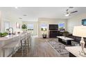 Open-concept living room featuring wood-look tile flooring, recessed lighting, and a ceiling fan at 8990 Ace Loop, Champions Gate, FL 33896