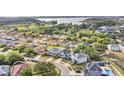 Expansive aerial view of a residential neighborhood with lush landscaping and a serene lake in the background at 11603 Malverns Loop, Orlando, FL 32832