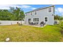 Spacious backyard featuring a well-maintained lawn, patio with a dining set, and mature trees at 11603 Malverns Loop, Orlando, FL 32832