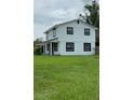 Rear view of a freshly painted two-story home with a spacious, green lawn at 124 Cinnamon Dr, Orlando, FL 32825