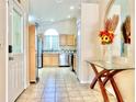 View of tiled entryway leading to kitchen, featuring glass table and decorative floral arrangement at 162 Seneca Point Trl, Kissimmee, FL 34746