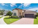 Beautiful one-story home with a two-car garage, manicured landscaping, and a brick driveway at 2009 Napoli Dr, St Cloud, FL 34771