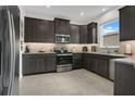 Modern kitchen featuring dark cabinetry, granite countertops, and stainless steel appliances at 2009 Napoli Dr, St Cloud, FL 34771