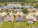Aerial view of the property featuring a lush backyard, neighboring homes, and a serene lake nearby at 2547 Raccoon Run Ln, Orlando, FL 32837