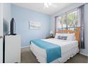 Cozy bedroom with a light-blue wall, a comfy queen bed and a bright window with blinds at 2550 Renshaw St, Kissimmee, FL 34747