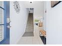Welcoming entryway featuring a staircase and tile flooring, leading into the kitchen and living areas at 2550 Renshaw St, Kissimmee, FL 34747