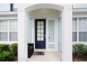 Close-up of the entrance with a dark-blue front door and charming front-porch with plants at 2550 Renshaw St, Kissimmee, FL 34747
