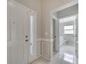 Foyer featuring a glass panel front door, neutral paint, tile flooring, and bathroom access at 2810 Maguire Dr, Kissimmee, FL 34741