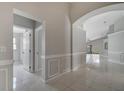 Hallway featuring tile floors, neutral paint and an arched doorway to a living space at 2810 Maguire Dr, Kissimmee, FL 34741