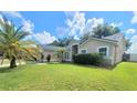 Spacious front yard with a well-maintained lawn, complemented by a palm tree and a charming single-story home at 283 Pine Arbor Dr, Orlando, FL 32825