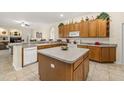 Spacious kitchen with tile flooring, a center island, and lots of wooden cabinets for ample storage at 305 Grand Reserve Dr, Davenport, FL 33837