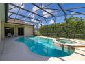 A sparkling screened-in pool with an attached hot tub offers a private outdoor oasis and lush landscaping at 305 Grand Reserve Dr, Davenport, FL 33837