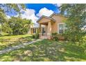Charming single-Gathering home with a covered porch, green lawn, and mature trees in a peaceful setting at 3125 Grasmere View Pkwy, Kissimmee, FL 34746
