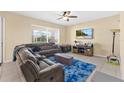 Comfortable living room with a large sectional sofa, bright blue rug, and a ceiling fan at 3125 Grasmere View Pkwy, Kissimmee, FL 34746