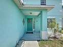 Inviting front entrance featuring an attractive teal front door, a decorative wreath, and stylish wall decor at 336 Hollingshead Loop, Davenport, FL 33896