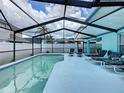 Relaxing screened-in pool area with lounge chairs, perfect for outdoor entertaining and enjoying the Florida sunshine at 336 Hollingshead Loop, Davenport, FL 33896