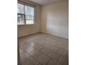 Bedroom featuring neutral walls, tile floors, and a bright window view at 3502 Windy Walk Way # 2-208, Orlando, FL 32837