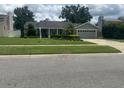 Well-maintained single-story home with a green lawn and an attached two-car garage at 3715 Sarasota Ct, Orlando, FL 32812