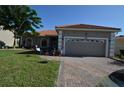 Charming single-story home featuring a two-car garage, brick paved driveway, and a well-manicured lawn at 455 Cinnamon Dr, Kissimmee, FL 34759