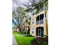 Multi-story building featuring private screened balconies, sidewalks, and lush landscaping around the property at 6100 Stevenson Dr # 202, Orlando, FL 32835