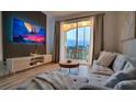 Cozy living room with modern decor, a balcony, and a large screen television at 8103 Coconut Palm Way # 203, Kissimmee, FL 34747