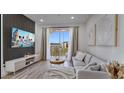 Comfortable living room featuring an outdoor balcony and a wall mounted television at 8103 Coconut Palm Way # 203, Kissimmee, FL 34747