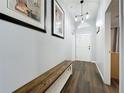 Welcoming hallway with wood flooring and elegant lighting leading to the front door and other areas at 838 Sandy Ridge Dr, Davenport, FL 33896