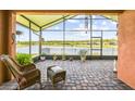 Relaxing screened-in lanai with wicker furniture overlooking a tranquil lake at 925 Grand Canal Dr, Poinciana, FL 34759