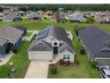 Charming single-story home with a well-manicured lawn, inviting entrance, solar panels, and two-car garage at 973 Corvina Dr, Davenport, FL 33897