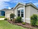 Close-up showcasing the professionally landscaped front yard with mulch beds and a variety of plants at 973 Corvina Dr, Davenport, FL 33897
