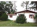 Cozy home exterior with well-established trees and bushes in the front yard at 12019 Ne 212Th Street Rd, Fort Mc Coy, FL 32134