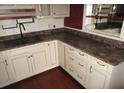 Kitchen featuring light-colored cabinetry, dark countertops, and ample storage space at 12019 Ne 212Th Street Rd, Fort Mc Coy, FL 32134