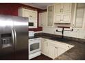 Spacious kitchen featuring stainless steel appliances, white cabinets and dark countertop at 12019 Ne 212Th Street Rd, Fort Mc Coy, FL 32134