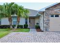 Charming home with desert landscaping, brick paver driveway, and a two-car garage with stone accents at 1749 Christina Lee Ln, St Cloud, FL 34769