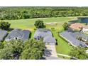 A beautiful aerial view of a well-manicured lawn and lovely home bordering a lush green golf course at 1810 Lee Janzen Dr, Kissimmee, FL 34744