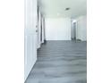 Spacious living room features new gray flooring and freshly painted white walls, offering a modern aesthetic at 2221 Wakulla Way, Orlando, FL 32839