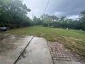 Spacious backyard featuring a mix of grass, concrete, and brick patio area, enclosed by a chain-link fence at 2549 Olive Ave, Lake Wales, FL 33898
