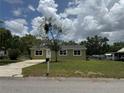 Home's front exterior showing front yard, driveway, and an olive drab exterior with white framed windows at 2549 Olive Ave, Lake Wales, FL 33898