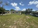 Exterior front view of olive drab house and partially overgrown lawn with a small tree and fence line at 2549 Olive Ave, Lake Wales, FL 33898