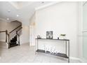 Bright foyer with decorative table, tile floors, staircase, and access to other rooms at 2740 Picasso Ct, Kissimmee, FL 34743