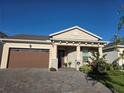 Attractive single-Gathering home featuring a two-car garage and a covered front porch with stone pillars at 2853 Willowseed Ln, St Cloud, FL 34772