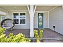 Inviting front porch with decorative seat, pillar, and door to welcome you home at 3026 Prospect Trl, St Cloud, FL 34771