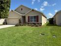 Charming single-story home with green lawn and nicely manicured landscaping at 306 Briar Patch Loop, Davenport, FL 33896