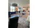 Open-concept living room with tiled flooring, a dining area, a kitchen island, and an adjacent sitting area at 3184 Songbird Cir, Harmony, FL 34773