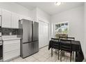 Eat-in kitchen featuring stainless steel refrigerator and dining table near a bright window at 3217 Whooping Crane Run, Kissimmee, FL 34741