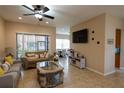Open-concept living room with tile floors, a mounted TV, and views into the dining area and kitchen at 406 Cinnamon Dr, Kissimmee, FL 34759